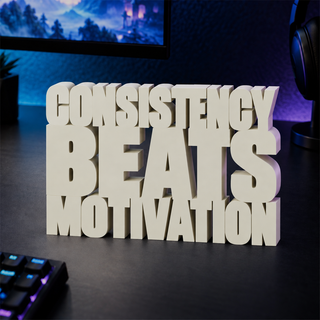 Consistency Beats Motivation desk letters on a gaming desk
