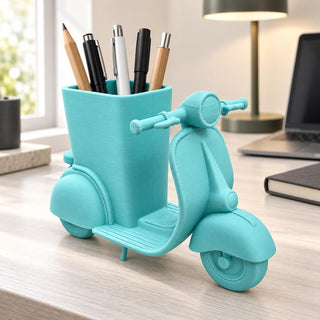 Scooter pencil holder on a bright desk beside a laptop and notebook
