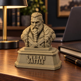 The Warrior sculpture on a desk beside a lamp and notebook