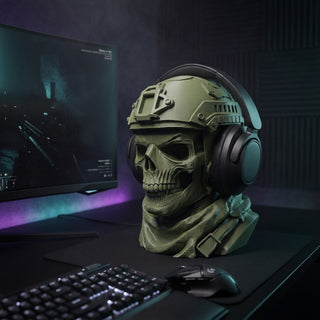 Skull headphone holder on a gaming desk beside an ultrawide monitor and mechanical keyboard