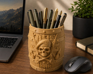 Skull pen stand holding pens on a wooden work desk beside a laptop