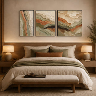 Framed relief textured wall art above a bed in a warm bedroom