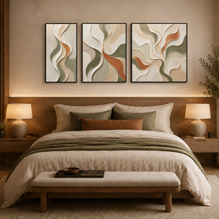 Framed abstract relief wall art above a bed in a warm bedroom