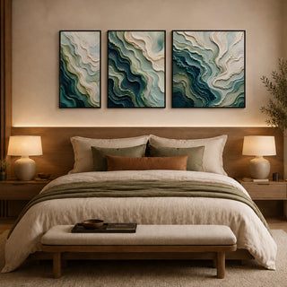 Framed abstract relief wall art above a bed in a warm bedroom