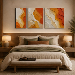 Framed abstract relief wall art above a bed in a warm bedroom