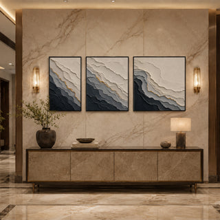 Black box framed grey abstract relief triptych above a marble console