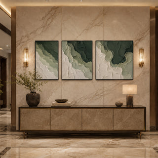 Black box framed green abstract relief triptych above a marble console