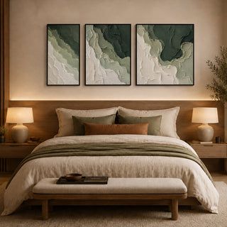 Framed abstract relief wall art above a bed in a warm bedroom