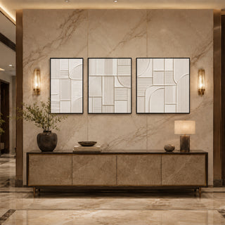 Black box framed ivory abstract relief triptych above a marble console