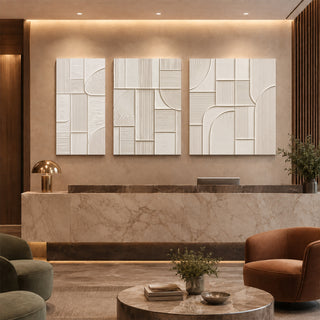 Ivory geometric abstract relief canvas set of 3 in a marble reception lobby