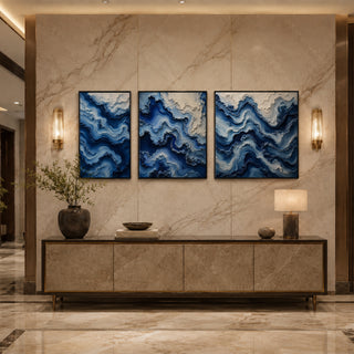 Black box framed blue abstract relief triptych above a marble console