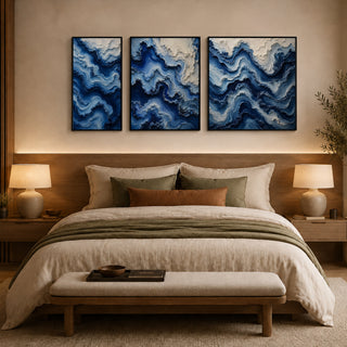 Framed abstract relief wall art above a bed in a warm bedroom